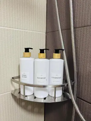 a shelf with three moisturizers on it in a bathroom at Metro Stay Grand View Tower in Manila