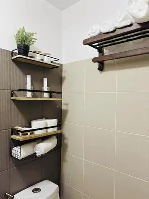 a bathroom with a toilet and some towels at Metro Stay Grand View Tower in Manila