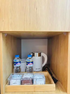 a cupboard with two containers of water and a coffee maker at Metro Stay Grand View Tower in Manila