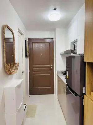 a kitchen with a brown door and a refrigerator at Metro Stay Grand View Tower in Manila