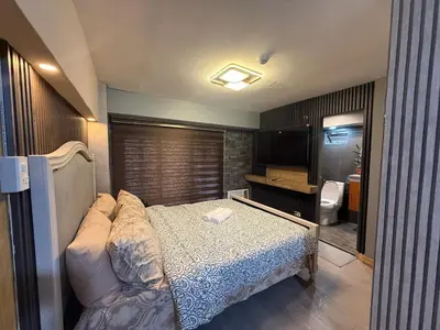 a small bedroom with a bed and a bathroom at 2 bedroom loft type with 2 baths Near Rockwell in Manila