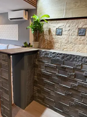 a kitchen with a counter with a brick wall at 2 bedroom loft type with 2 baths Near Rockwell in Manila