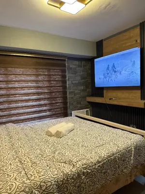 a bedroom with a bed and a flat screen tv at 2 bedroom loft type with 2 baths Near Rockwell in Manila