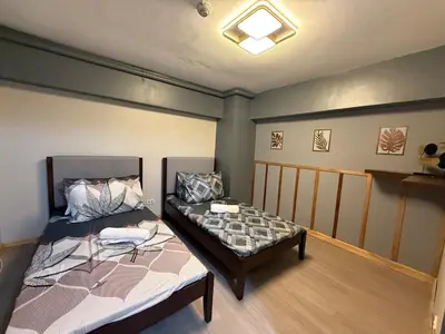 a bedroom with a bed and a table in it at 2 bedroom loft type with 2 baths Near Rockwell in Manila