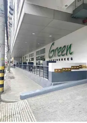 a store with a green sign on the side of a building at 1Bed Room Staycation at Green Residences in Manila