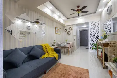 a living room with a blue couch and a dining room at 1Bed Room Staycation at Green Residences in Manila