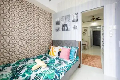 a bedroom with a bed with colorful pillows at 1Bed Room Staycation at Green Residences in Manila