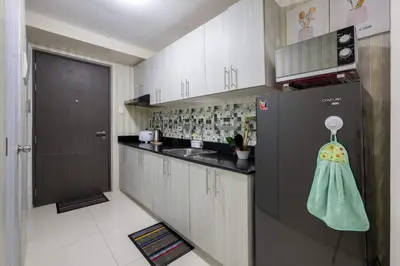 a small kitchen with a refrigerator and a sink at 1Bed Room Staycation at Green Residences in Manila