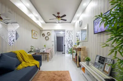 a living room with a blue couch and a ceiling fan at 1Bed Room Staycation at Green Residences in Manila
