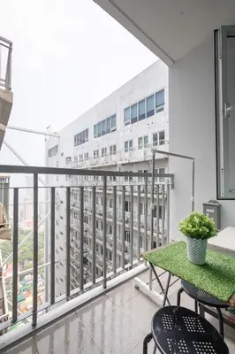 a balcony with a table and chairs and a building at 1Bed Room Staycation at Green Residences in Manila