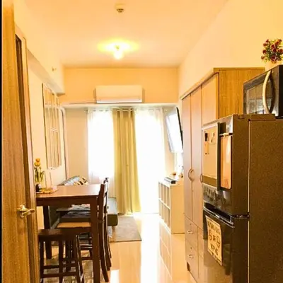 a small kitchen with a table and a refrigerator at Place To Stay Near US Embassy Front Of Manila Bay in Manila
