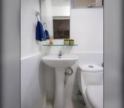 a white bathroom with a sink and a toilet at NEW AND AFFORDABLE 2BR LOFT at THE FORT BGC 200mbps WiFi in Manila