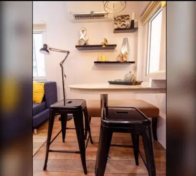 a living room with a table and two stools at NEW AND AFFORDABLE 2BR LOFT at THE FORT BGC 200mbps WiFi in Manila