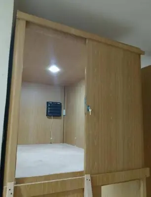 ajar door of a room with a bed in it at Capsule bed in Manila