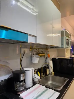 a kitchen counter with a sink and a microwave at Infinity Suites Makati in Manila