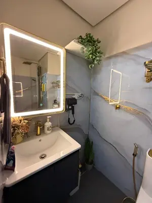 a bathroom with a sink and a mirror at Infinity Suites Makati in Manila