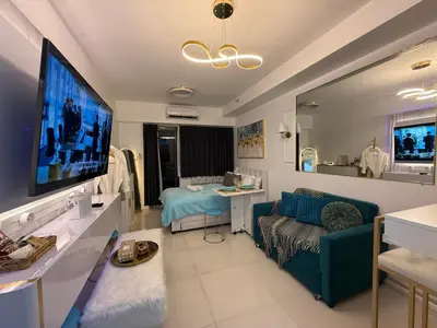 a living room with a couch and a tv at Infinity Suites Makati in Manila