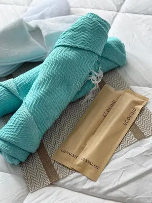 two towels on a bed with tags on them at Infinity Suites Makati in Manila