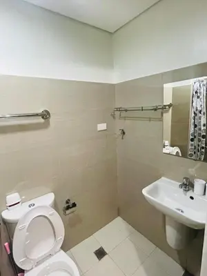 a bathroom with a toilet and a sink at Shore 2 Residences Moa Pasay in Manila