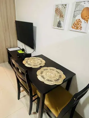 a black dining room table with two plates on it at Shore 2 Residences Moa Pasay in Manila
