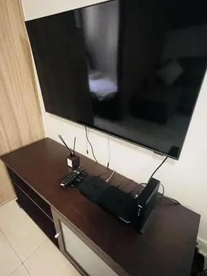 a television on top of a table with a remote control at Shore 2 Residences Moa Pasay in Manila
