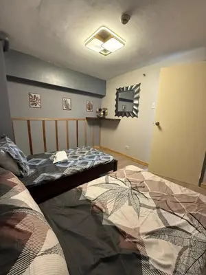 a bedroom with two beds and a door open at 2 bedroom loft type with 2 baths Near Ortigas Cbd in Manila