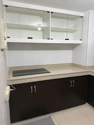 a kitchen with black cabinets and white walls at 2 bedroom loft type with 2 baths Near Ortigas Cbd in Manila