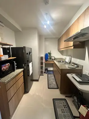 a small kitchen with a refrigerator and a sink at Casa de Caysido in Manila
