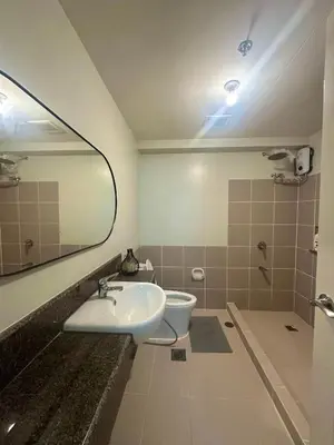 a bathroom with a sink and a toilet and a mirror at Casa de Caysido in Manila