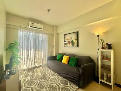 a living room with a couch and a window at Casa de Caysido in Manila