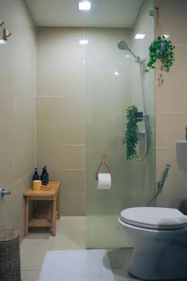 a bathroom with a toilet and a glass shower at Upscale Stylish Suite Near BGC and View of Venice Grand Canal Mall in Manila