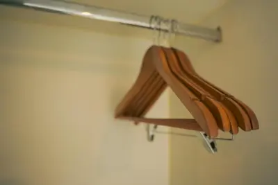 a wooden hanger in a bathroom with a towel rack at Upscale Stylish Suite Near BGC and View of Venice Grand Canal Mall in Manila