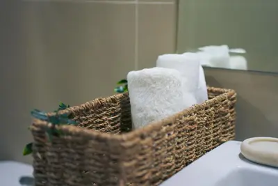 a basket of towels sitting on a counter in a bathroom at Upscale Stylish Suite Near BGC and View of Venice Grand Canal Mall in Manila