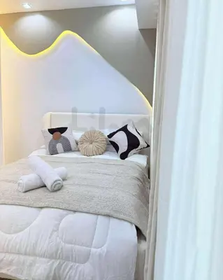 a white bed with two pillows on top of it at Lilom in Manila