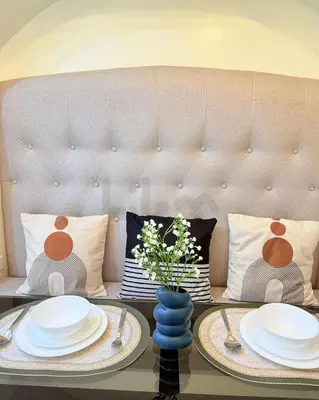 a table with plates and a vase with flowers on it at Lilom in Manila