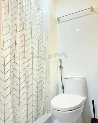 a bathroom with a toilet and a shower curtain at Lilom in Manila