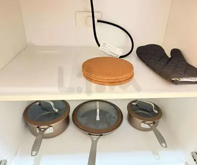 a shelf with three pans and a cake on it at Lilom in Manila
