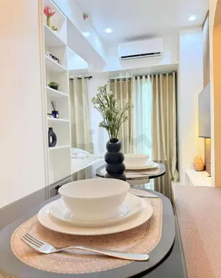 a table with two plates and a vase on it at Lilom in Manila