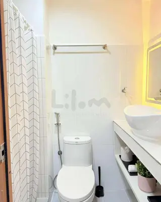 a white bathroom with a toilet and a sink at Lilom in Manila