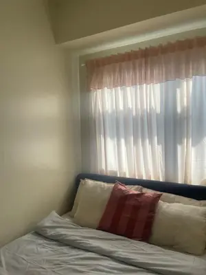 a bed with a pillow and a window at cozy 1 bedroom retreat Walk to Moa in Manila