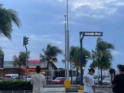 a group of people standing around a street sign at cozy 1 bedroom retreat Walk to Moa in Manila