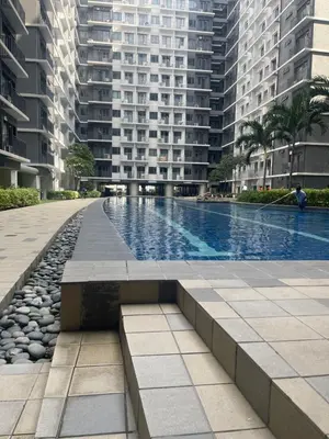 a swimming pool in a city with tall buildings at cozy 1 bedroom retreat Walk to Moa in Manila