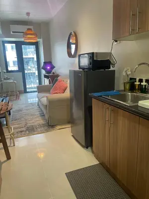a kitchen with a sink and a refrigerator in a room at cozy 1 bedroom retreat Walk to Moa in Manila