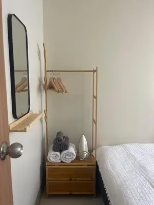 a room with a bed and a mirror and a table at cozy 1 bedroom retreat Walk to Moa in Manila
