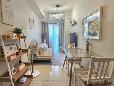 a living room with a table and a dining room at Shell Residences Mall of asia Rs in Manila