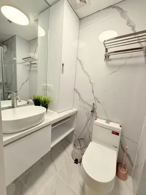 a white bathroom with a toilet and a sink at Shell Residences Mall of asia Rs in Manila