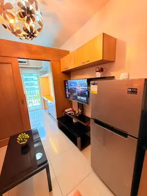 a kitchen with a stainless steel refrigerator and a table at Shell Residences Mall of asia Rs in Manila