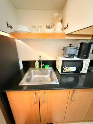 a kitchen with a sink and a microwave at Shell Residences Mall of asia Rs in Manila