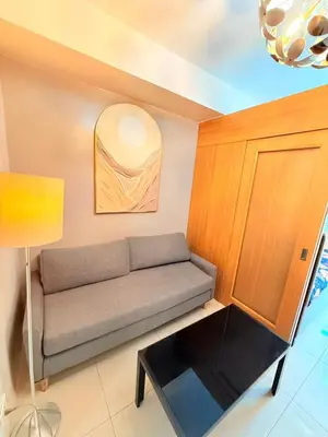 a living room with a couch and a table at Shell Residences Mall of asia Rs in Manila