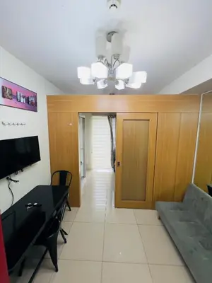 a living room with a couch and a table at Shell Residences Mall of asia Rs in Manila